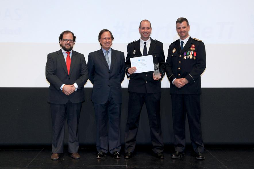 Festividad de San Juan de la Policía Local - El alcalde García de Vinuesa y otras autoridades en el escenario con un galardonado.