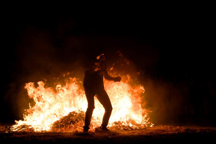 Noche de San Juan 2018 - Actividades y Hoguera de San Juan - Imagen de la llamas de la hoguera y los perfiles de personas alrededor del fuego.