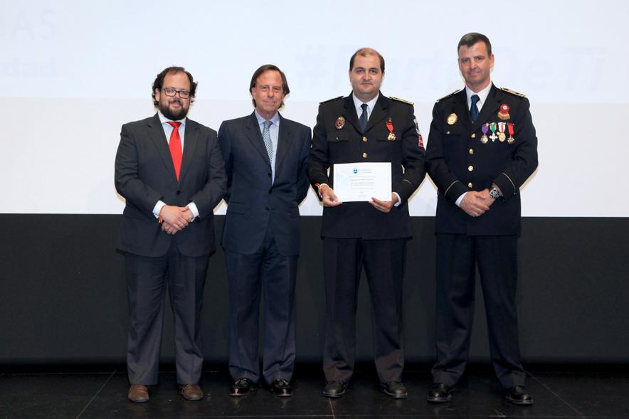 Festividad de San Juan de la Policía Local - El alcalde García de Vinuesa y otras autoridades en el escenario con un galardonado.