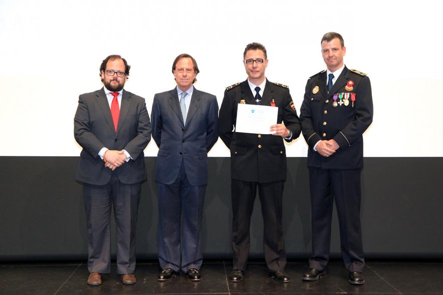 Festividad de San Juan de la Policía Local - El alcalde García de Vinuesa y otras autoridades en el escenario con un galardonado.