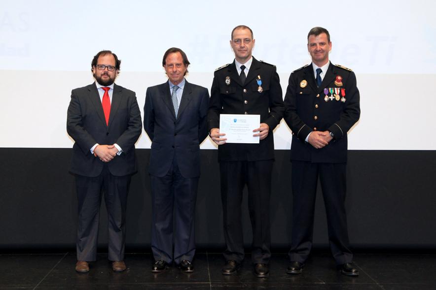 Festividad de San Juan de la Policía Local - El alcalde García de Vinuesa y otras autoridades en el escenario con un galardonado.