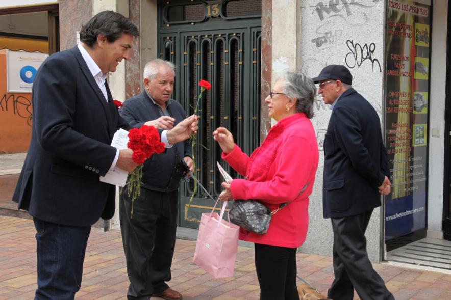 Concejal Martínez Rodríguez entregando claveles