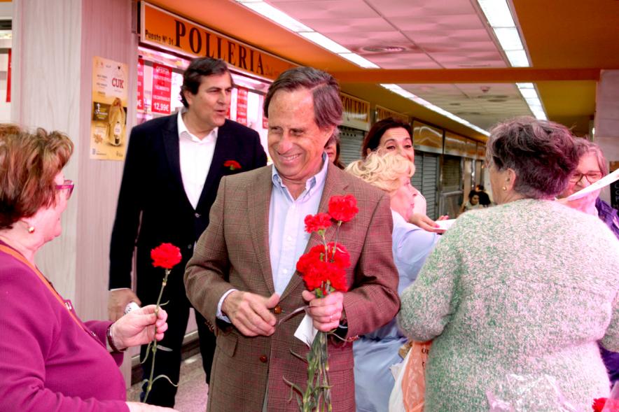 Alcalde García de Vinuesa entregando claveles y programa de fiestas