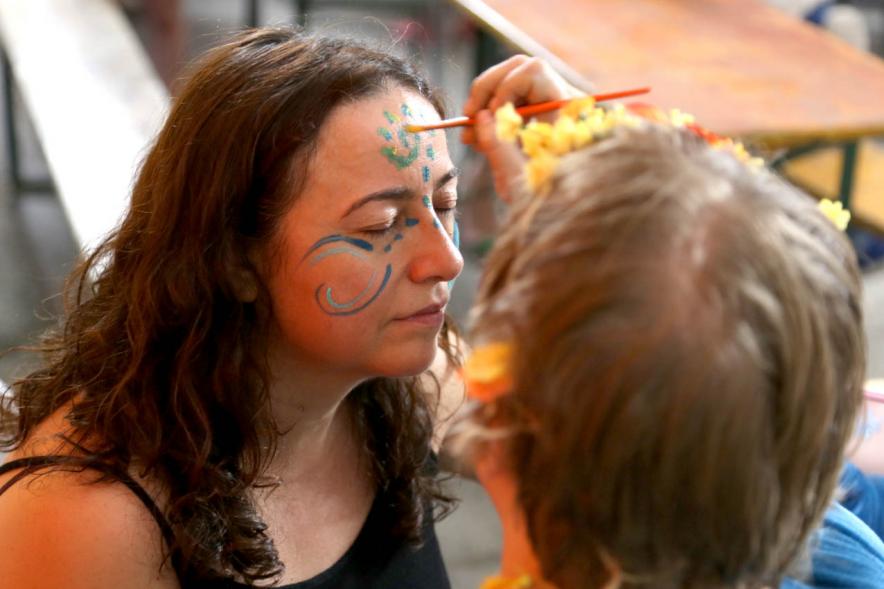 Artista pintando la cara de una participante. Noche de San Juan 2019