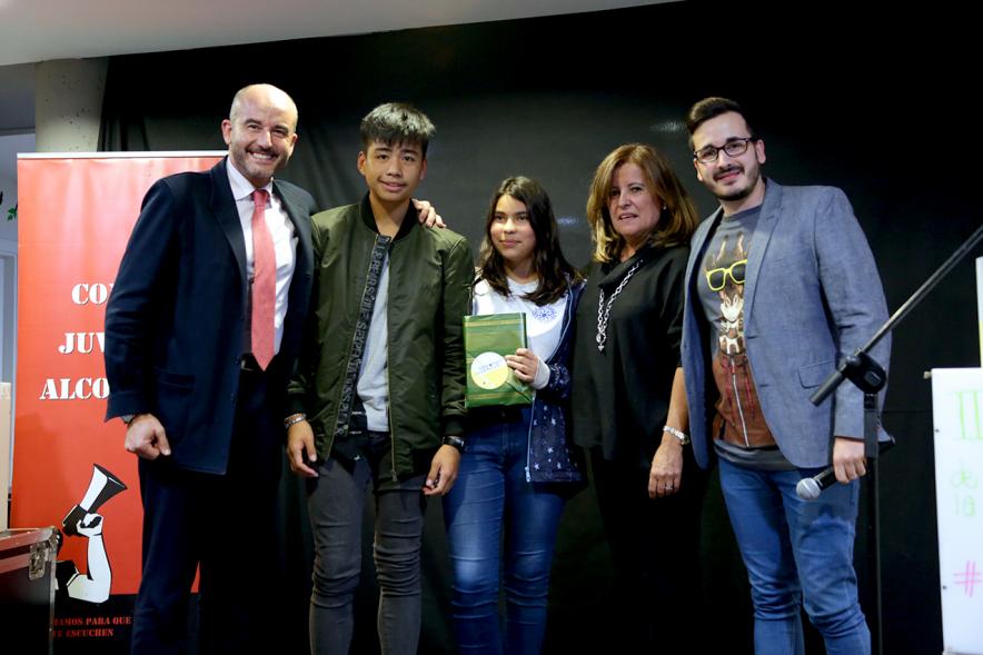 Inauguración Semana de la Juventud - Entrega de Premios Jovenes - Imagen de la entrega de un premio a una de las personas que esta en el escenario.