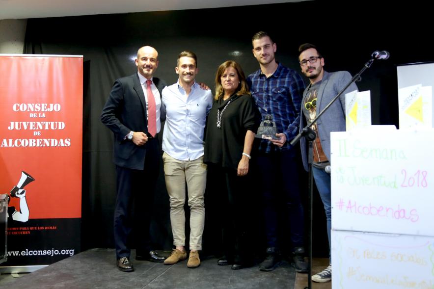 Inauguración Semana de la Juventud - Entrega de Premios Jovenes - Imagen de la entrega de una Menina a una de las personas que esta en el escenario.