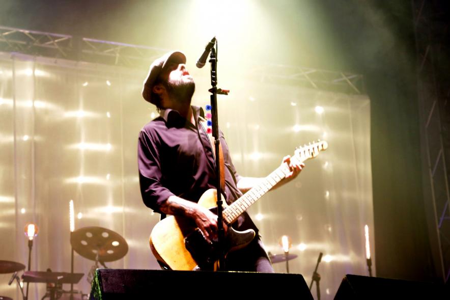 Cantante con guitarra bajo los focos 