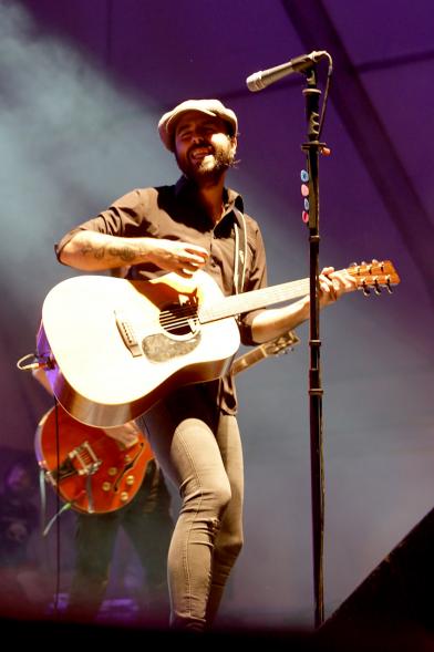 Cantante con guitarra bajo los focos 