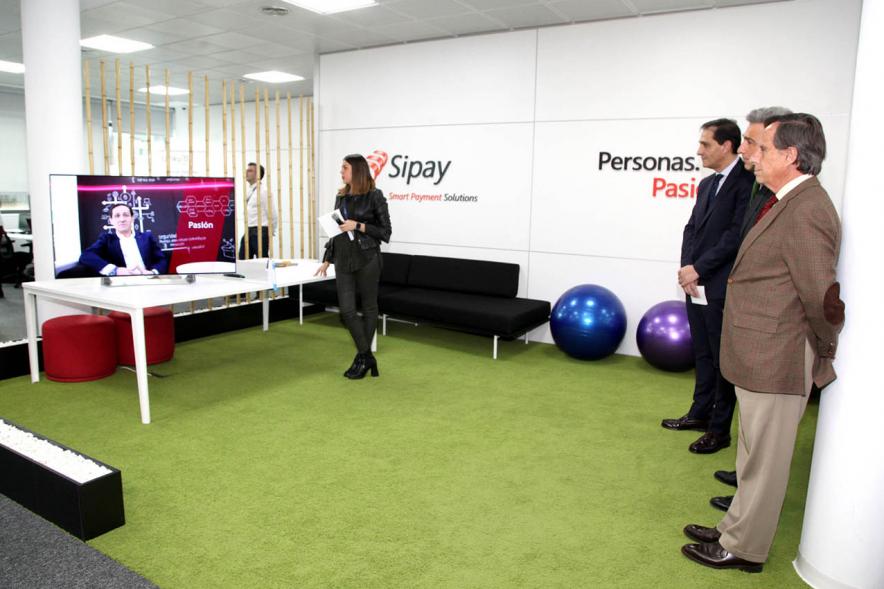 Visita a Empresa SIPAY - Imagen de las autoridades mirando un spot en una pantalla.