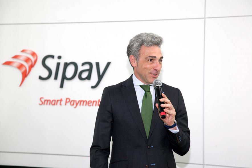 Visita a Empresa SIPAY - Imagen de un momento del discurso de Javier Ruiz Santiago, Viceconsejero de Economía y Competitividad de la Comunidad Autónoma de Madrid que aparece delante del logo de la empresa.
