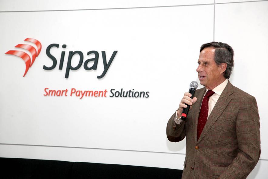 Visita a Empresa SIPAY - Imagen del alcalde García de Vinuesa posando junto al logo de la empresa.