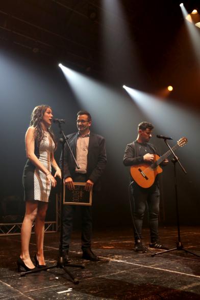 Noche de Talentos ITN - Imagen del presentador entrevistando a un dúo musical en el escenario.