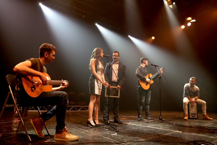 Noche de Talentos ITN - Imagen del presentador entrevistando a un dúo musical  en el escenario.