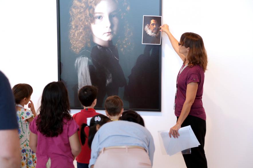 Taller de Fotografía con Niños en el Centro de Arte - Imagen de monitora del taller impartiendo clase a los niños participantes.