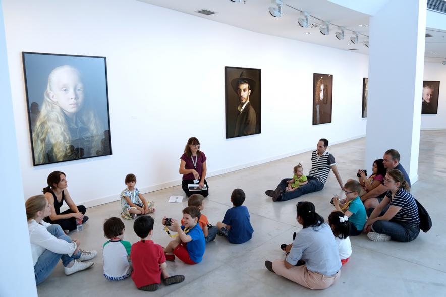 Taller de Fotografía con Niños en el Centro de Arte -Imagen de monitora del taller impartiendo clase a los niños participantes.