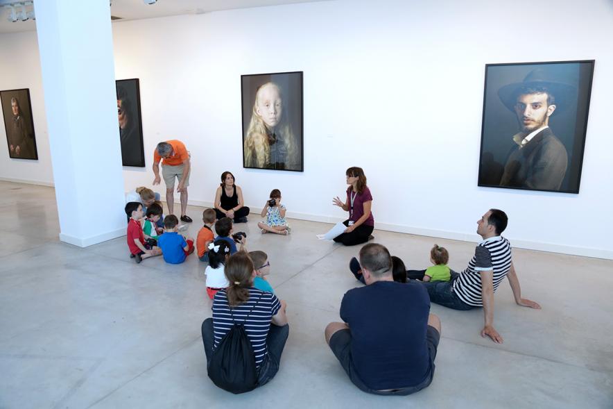 Taller de Fotografía con Niños en el Centro de Arte - Imagen de monitora del taller impartiendo clase a los niños participantes.