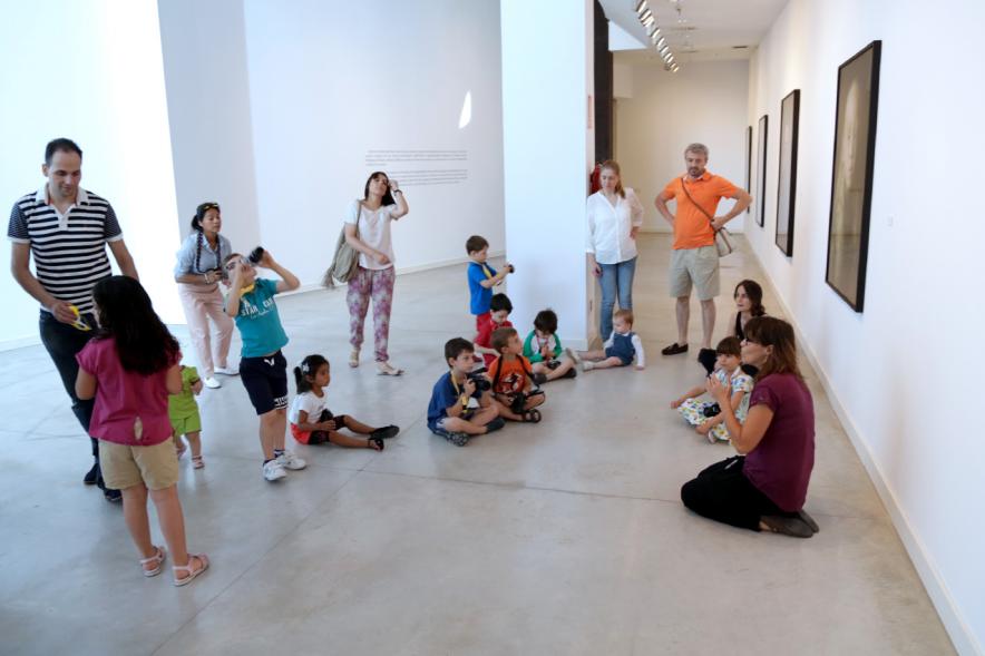 Taller de Fotografía con Niños en el Centro de Arte - Imagen de monitora del taller impartiendo clase a los niños participantes.
