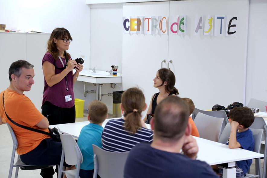 Taller de Fotografía con Niños en el Centro de Arte - Imagen de monitora del taller impartiendo clase a los niños participantes.