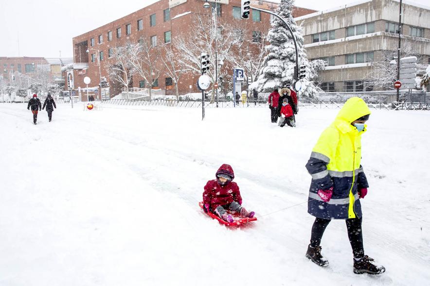 Ciudadanos con trineo jugando en las calles nevadas