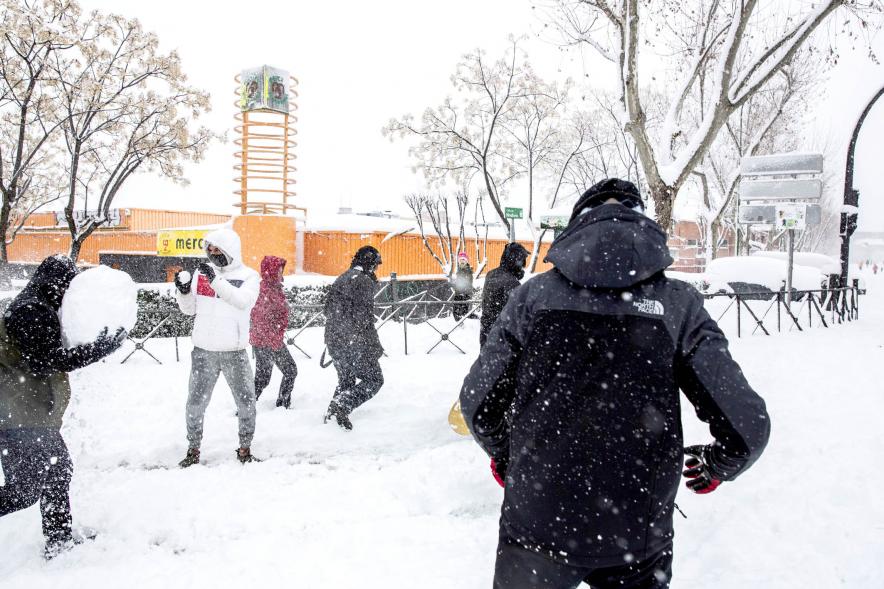 Gente divirtiéndose en la calle mientras nieva