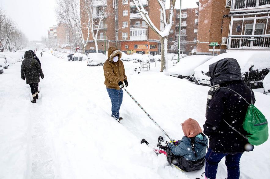 Ciudadanos con trineo jugando en las calles nevadas