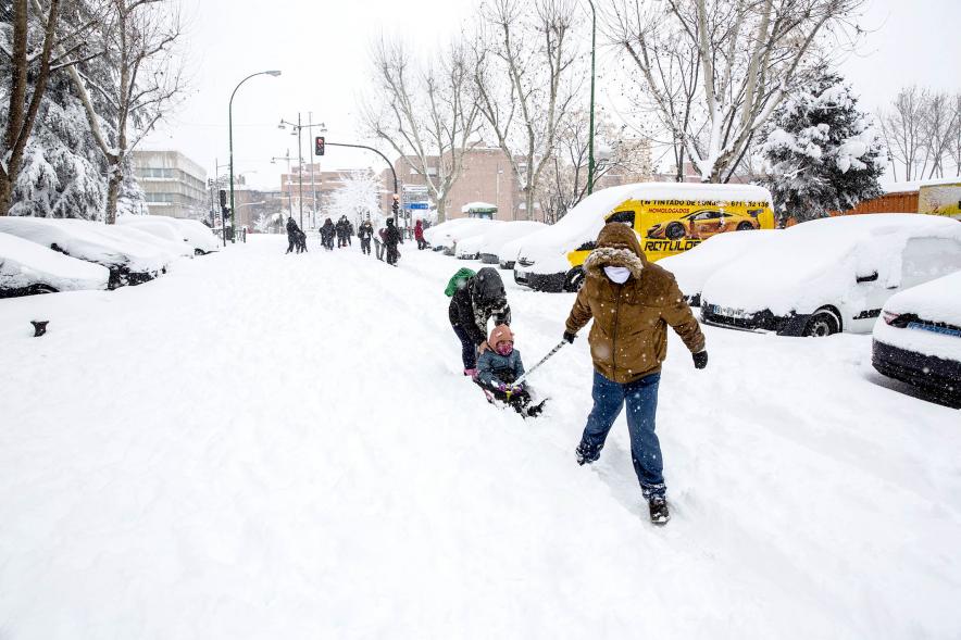 Ciudadanos con trineo jugando en las calles nevadas