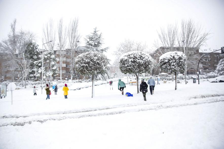 Gente divirtiéndose en la calle mientras nieva