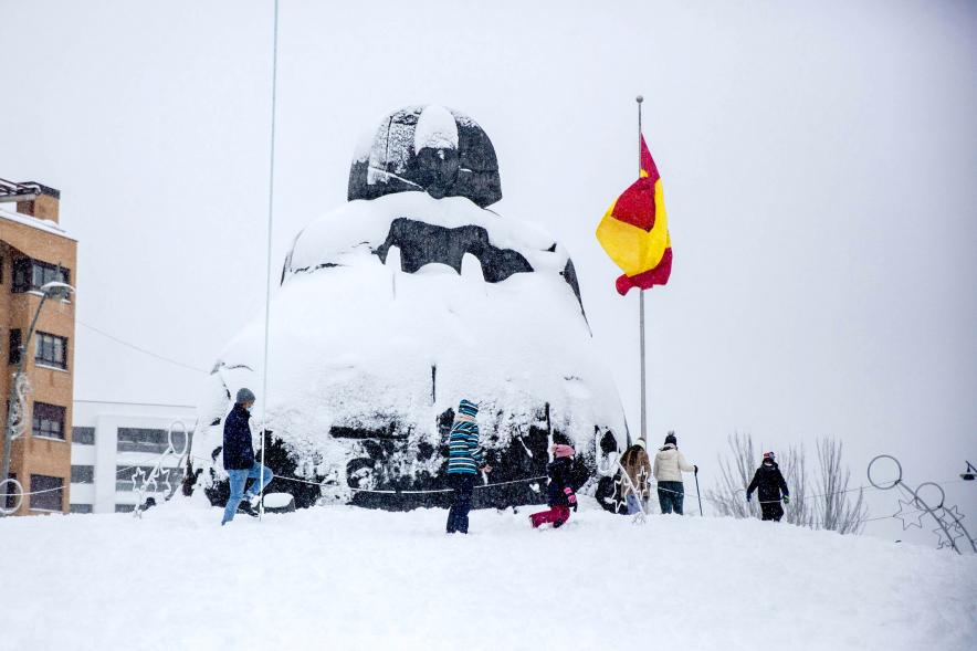 Menina nevada con bandera al fondo
