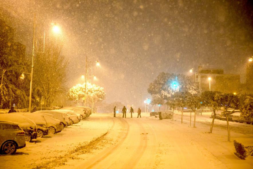 Gente divirtiéndose en la calle mientras nieva