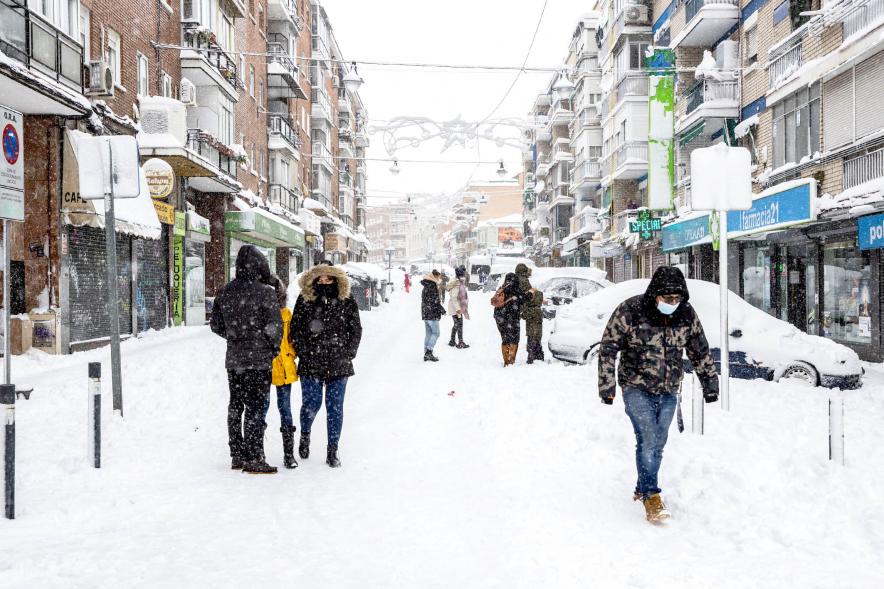 Gente divirtiéndose en la calle mientras nieva