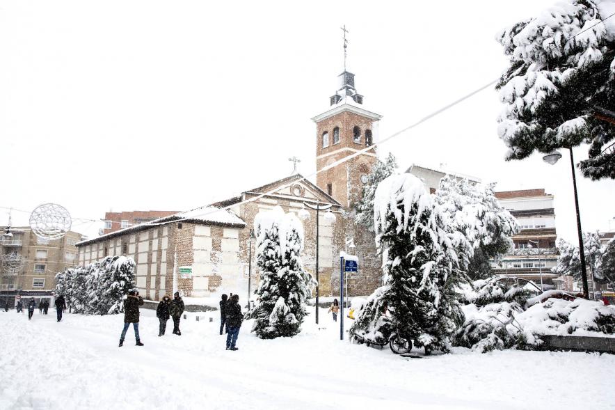 Gente en las calles nevadas frente a la iglesia