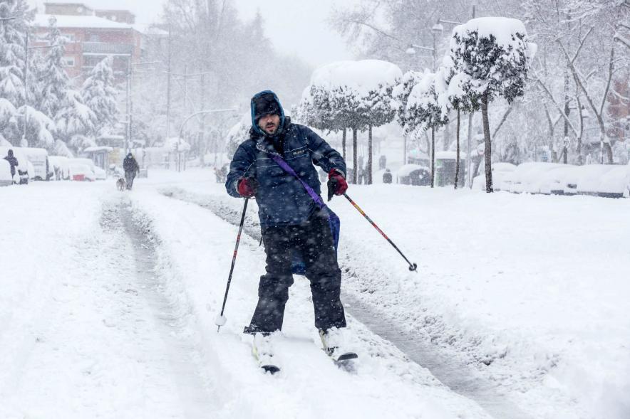 Hombre esquiando en las calles nevadas