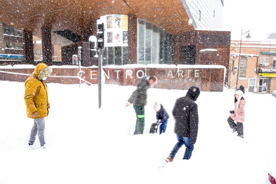Gente jugando con la nieve frente al centro de arte