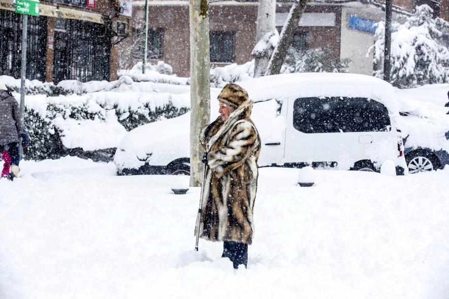 Señora con abrigo de pieles disfrutando de la nieve
