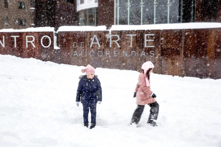Niños juegan frente al centro de arte en la calle nevada