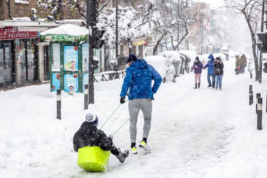 Ciudadanos con trineo jugando en las calles nevadas