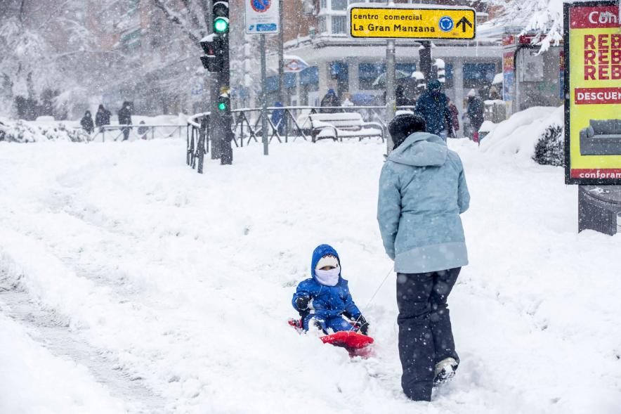 Ciudadanos con trineo jugando en las calles nevadas