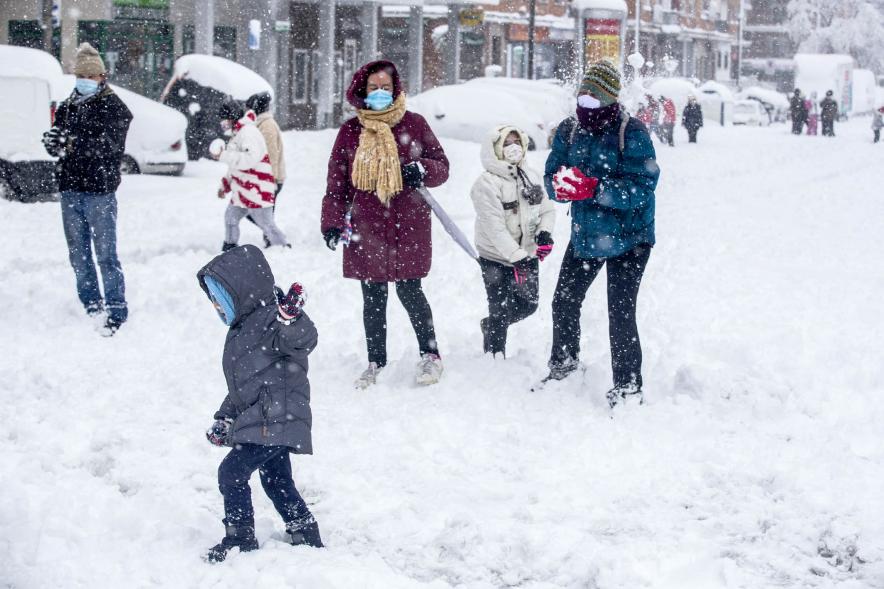Gente divirtiéndose en la calle mientras nieva
