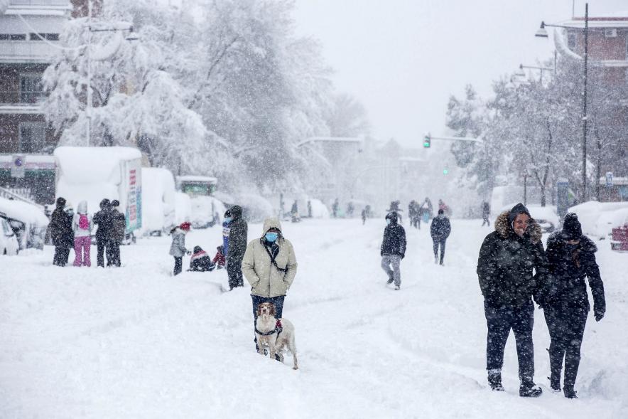 Gente divirtiéndose en la calle mientras nieva