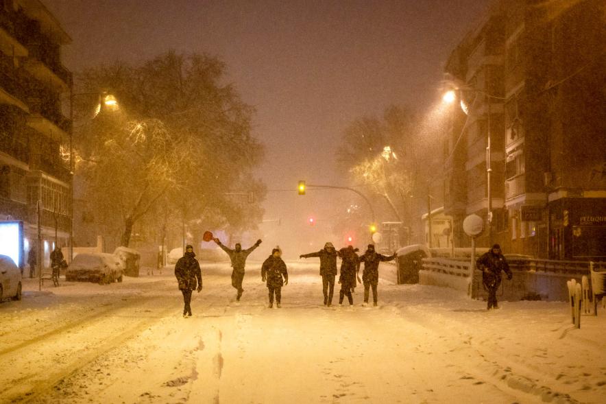 Gente divirtiéndose en la calle mientras nieva