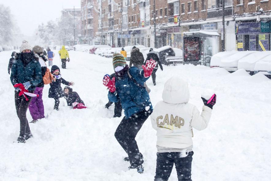 Gente divirtiéndose en la calle mientras nieva