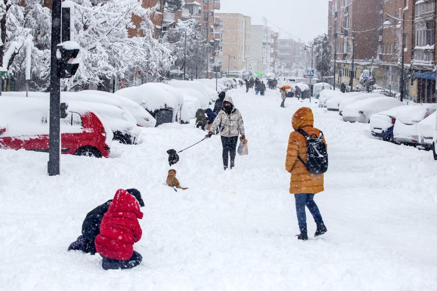 Gente divirtiéndose en la calle mientras nieva
