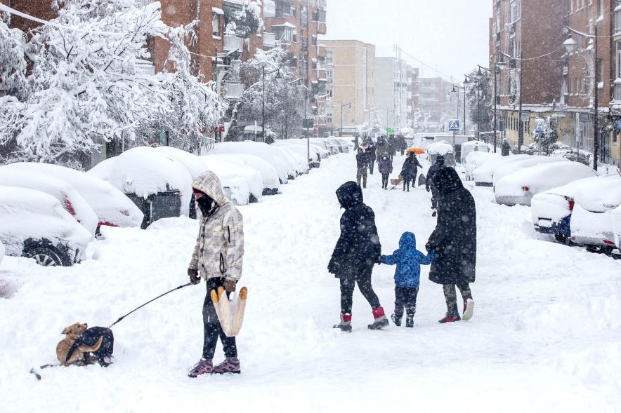 Gente divirtiéndose en la calle mientras nieva