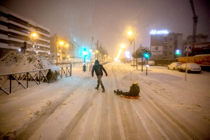 Ciudadanos con trineo jugando en las calles nevadas