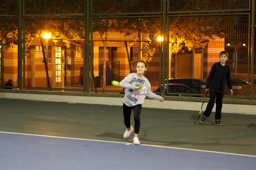 Presentación del Torneo de Tenis La Menina 2017 - Imagen de niña devolviendo la pelota en la pista de tenis.
