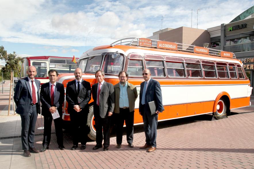 Miembros del ayuntamiento posando frente a autobus retro