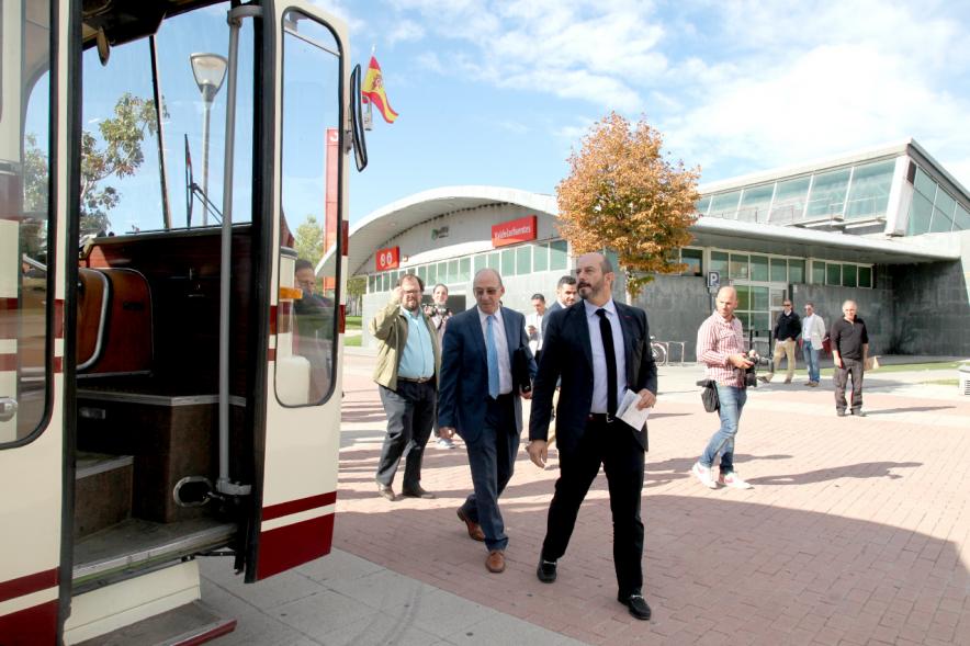 Miembros del ayuntamiento observando un autobus retro