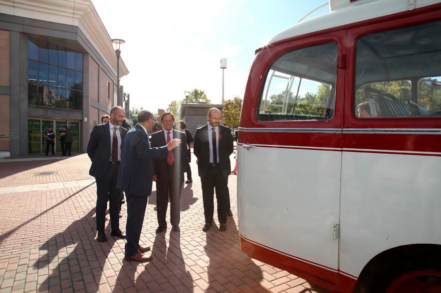 Personalidades ante un autobus expuesto
