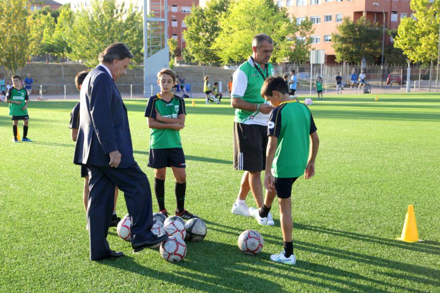 Visita a Campos de Fútbol de CD Valdelasfuentes - Imagen del alcalde García de Vinuesa charlando con el entrenador de un equipo de fútbol y algunos jugadores.