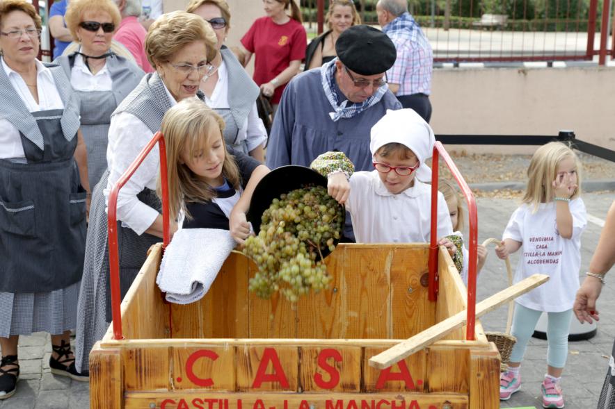 Pisada de la Uva en la Fiesta de la Vendimia de la Casa de Castilla La Mancha - Los niños colaboran en echar uvas.